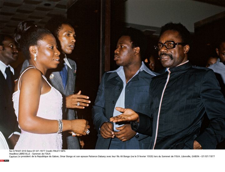 Le président du Gabon Omar Bongo (à droite) et son épouse Patience Dabany, accompagnés de leur fils Ali Bongo (au centre), lors du sommet de l'Organisation de l'unité africaine (OUA) à Libreville, au Gabon, le 7 juillet 1977. (FRILET/SIPA)