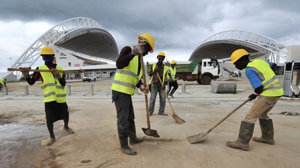 Des ouvriers d&eacute;blaient la route qui m&egrave;ne au stade de l'Amiti&eacute; sino-gabonaise, &agrave; Libreville (Gabon), le 9 novembre 2011.&nbsp; (SIA KAMBOU / AFP)