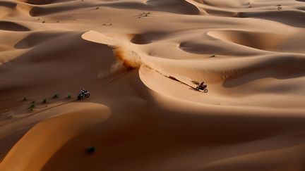 Le pilote américain Skyler Howes (HVA) poursuit le Français Adrien van Beveren (Honda) à travers les immenses dunes de l'Empty Quarter, lors de la 11e étape du Dakar, le 12 janvier 2023. (FRANCK FIFE / AFP)