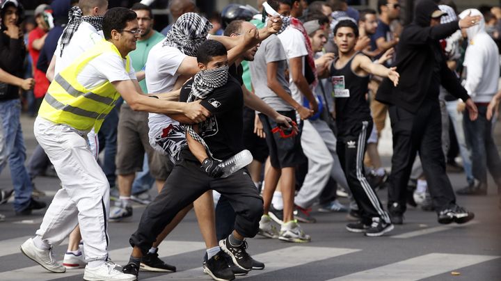 Un membre du service d'ordre tente d'emp&ecirc;cher un manifestant pro-palestinien de jeter un projectile &agrave; travers la place de la R&eacute;publique de Paris, le 26 juillet 2014. (KENZO TRIBOUILLARD / AFP)