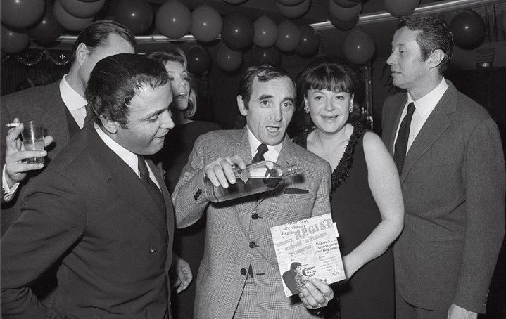 Avec Charles Azanavoue et le comédien Michel Auclair (à droite), Régine fête son premier disque le 27 novembre 1964
 (UPI / AFP)