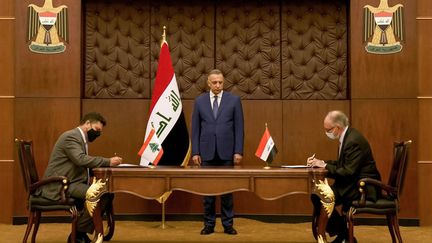 Le Premier ministre irakien Kadhemi (au centre) observe la signature de l'accord entre le Liban et l'Irak, le 24 juillet 2021. (IRAQI PRIME MINISTER'S PRESS OFFICE / AFP)