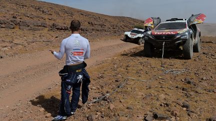 Sébastien Loeb attend de l'aide pour remorquer la Peugeot 2008 DKR lors de la 1ère étape du rallye du Maroc