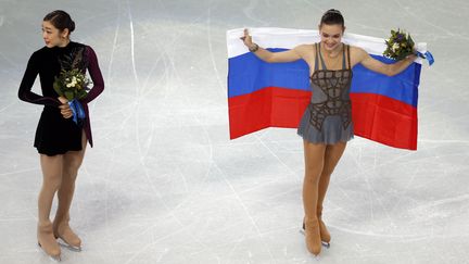 Une premi&egrave;re m&eacute;daille olympique en patinage artistique pour la Russie, mais sujette &agrave; controverse. La large victoire d'Adelina Sotnikova (&agrave; droite) devant la sud-cor&eacute;enne Kim Yu-Na (&agrave; gauche)&nbsp;a soulev&eacute; une cascade de r&eacute;actions et des soup&ccedil;ons. (ADRIAN DENNIS / AFP)