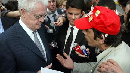 Le Premier ministre Lionel Jospin interpellé par un salarié de la biscuiterie LU, le 13 mars 2002. A sa gauche, Manuel Valls. (PHILIPPE DESMAZES / AFP)