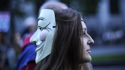 Une jeune femme portant le masque de Guy Fawkes manifeste contre le plan d'aust&eacute;rit&eacute; &agrave; Madrid (Espagne), le 13 octobre 2012. (PEDRO ARMESTRE / AFP)