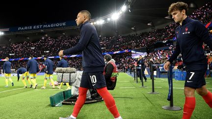 Kylian Mbappé et Antoine Griezmann entrent sur la pelouse du Parc des princes à l'occasion du match contre le Kazakhstan, qualificatif pour la Coupe du monde 2022, le 13 novembre 2021. (FRANCK FIFE / AFP)