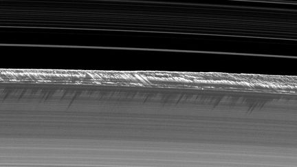 Mais les anneaux peuvent se déformer. Sur ce cliché, pris en 2009, on distingue, grâce à leur ombre projetée, des crêtes sur le bord des anneaux B. D'après les scientifiques, elles culminent à 2,5 kilomètres. Cette distorsion est causée par le passage de lunes qui déplacent de la matière. (NASA / JPL / SPACE SCIENCE INSTITUTE)