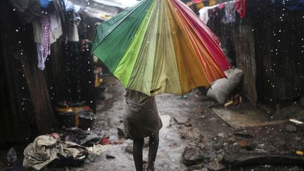 Une enfant sous un parapluie dans un bidonville de Freetown (Sierra Leone), le 22 ao&ucirc;t 2012. (REUTERS)