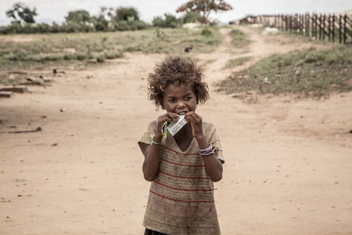 Une petite fille mange de la nourriture fournie par Action contre la faim et le World Food Programme, le 14 décembre 2018 à Ifotaka, dans le sud de Madagascar. (RIJASOLO / AFP)