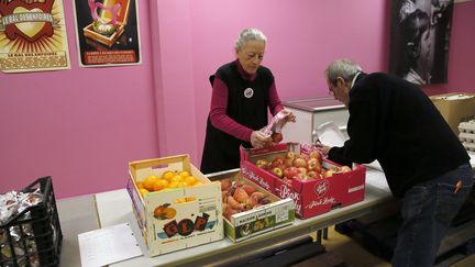 Des b&eacute;n&eacute;voles des Restos du c&oelig;ur pr&eacute;parent une distribution de repas &agrave; Paris, le 25 novembre 2013. (PATRICK KOVARIK / AFP)