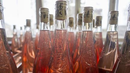 Des bouteilles de vin rosé sur une ligne d'embouteillage. (CHRISTIAN WATIER / MAXPPP)