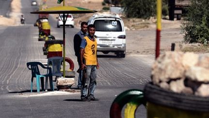 Kurde portant un T-shirt à l'effigie d’Abdullah Ocalan, leader du Parti des travailleurs du Kurdistan, à un check-point sur la route de la ville d’Afrin, située non loin de la frontière turque, le 23 Août 2012. ( AFP PHOTO / ARIS MESSINIS )