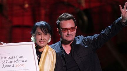 Elle reçoit des mains d’un de ses plus fervents admirateurs, le chanteur Bono du groupe U2, le prix «d'ambassadeur de conscience» décerné par Amnesty International.

«J'aime la chanson (Walk On, écrite par Bono, NDLR), car elle est très proche de ce que je ressens, que c'est à chacun de poursuivre sa route.»

Et de conclure : «C'est bien d'avoir des gens qui ont pour vous de la sympathie et vous comprennent. Mais, au bout du compte, ce sont vos jambes à vous qui doivent vous faire avancer.» (AFP PHOTO / PETER MUHLY)