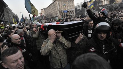 Les cercueils des manifestants, tu&eacute;s lors des affrontements, traversent une foule compacte. (LOUISA GOULIAMAKI / AFP)