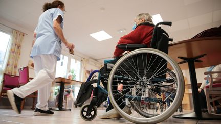 Une personne âgée en fauteuil roulant en Ehpad, aux côtés des soignants, dans le Finistère (Bretagne), le 25 novembre 2020. (LIONEL LE SAUX / MAXPPP)