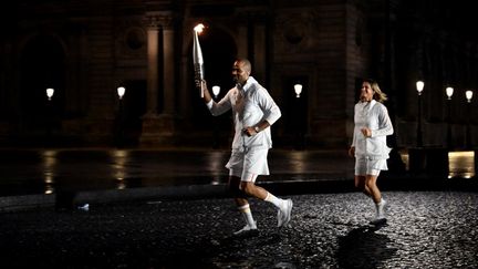 Tony Parker et Amélie Mauresmo ont parcouru la cour du Louvre, avant de rejoindre les derniers relayeurs dans le jardin des Tuileries. (OLIVIER MORIN / AFP)