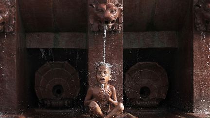 Un jeune gar&ccedil;on se rafra&icirc;chit dans une fontaine &agrave; New Delhi (Inde) o&ugrave; la temp&eacute;rature atteint les 45&deg;C, le 31 mai 2012. (ADNAN ABIDI / REUTERS)