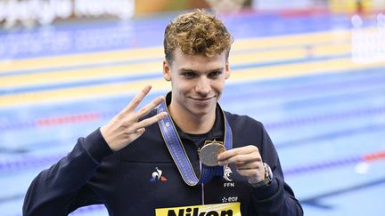 Léon Marchand, avec sa troisième médaille d'or autour du cou lors des Mondiaux de Fukuoka (Japon), le 27 juillet 2023. (HIROKI KAWAGUCHI / AFP)