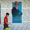 Un homme marche devant des affiches de candidats pour l'élection présidentielle iranienne, qui se tiendra le 18 juin, le 8 juin 2021, à Téhéran (Iran). (FATEMEH BAHRAMI / ANADOLU AGENCY / AFP)