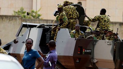 Des soldats tentent de disperser une manifestation du mouvement Le Balai Citoyen devant l'hôtel Liaco, à Ouagadougou, le 20 septembre 2015, après l'annonce du plan de sortie de crise de la Communauté économique des Etats de l'Afrique de l'Ouest (Cédéao).  (AFP PHOTO / SIA KAMBOU)