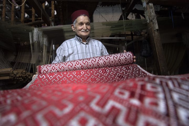 Abdelkader Ouazzani, le dernier maître du brocart, montre une étoffe dans son atelier situé à Fes au Maroc le 10 avril 2019. (FADEL SENNA / AFP)