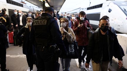 Des policiers patrouillent dans la gare de Lyon, à Paris, le 26 mars 2021, pour inspecter les justificatifs de voyage des voyageurs. (THOMAS COEX / AFP)