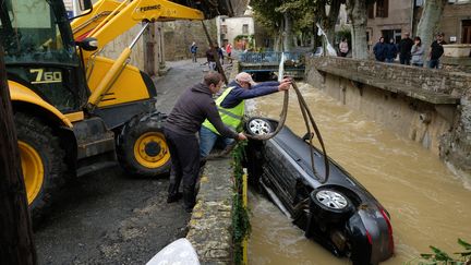 Une voiture est retirée d'un cours d'eau, le 15 octobre 2018, à Villegailhenc (Aude), après des inondations dévastatrices. (ERIC CABANIS / AFP)