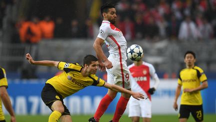 Radamel Falcao (à d.) devant JulianWeigl, lors du match Dormund-Monaco, le 12 avril 2017. (PATRIK STOLLARZ / AFP)