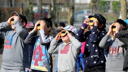 Des enfants observent l'&eacute;clipse de Soleil, &agrave; Colmar (Haut-Rhin), le 20 mars 2015. (  MAXPPP)