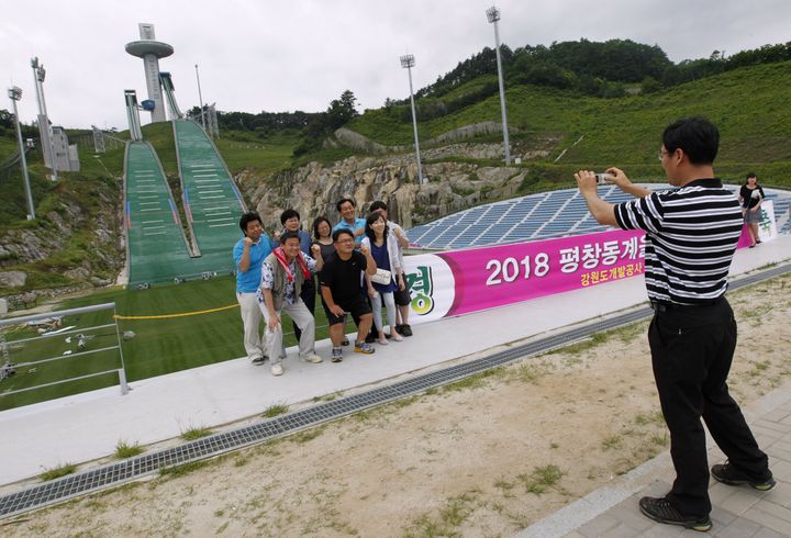 Des touristes se prennent en photo devant les installations de la ville de Pyeongchang, h&ocirc;te des JO d'hiver en 2018, le 7 juillet 2011.&nbsp; (JO YONG HAK / REUTERS)