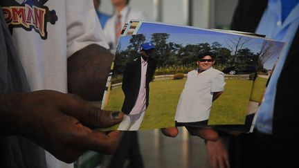 L'ancien joueur de basket Dennis Rodman montre une photo de lui avec le dirigeant nord-cor&eacute;en Kim Jong-un, &agrave; l'a&eacute;roport de P&eacute;kin (Chine), le 7 septembre 2013. (WANG ZHAO / AFP)