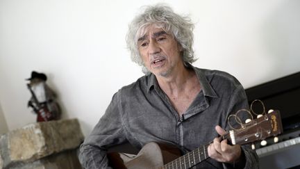 Louis Bertignac joue de la guitare dans sa maison de&nbsp;Fontainebleau (Seine-et-Marne) en 2014. (STEPHANE DE SAKUTIN / AFP)