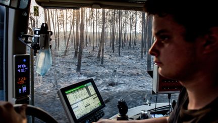 Un agriculteur transporte une cuve pleine d'eau pour aider les pompiers&nbsp;qui luttent contre l'incendie en cours à Landiras, en Gironde,&nbsp;le 18 juillet 2022. (IDHIR BAHA / HANS LUCAS / AFP)