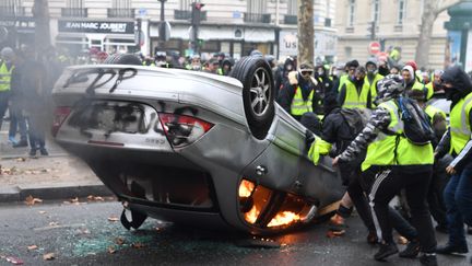 Une voiture est incendiée à côté des Champs-Elysées par des "gilets jaunes". (ALAIN JOCARD / AFP)