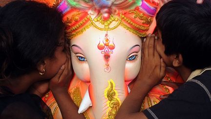 De jeunes hindous chuchotent leurs v&oelig;ux aux oreilles de Ganesh lors d'un festival &agrave; Chaturthi (Inde), le 23 septembre 2012. (INDRANIL MUKHERJEE / AFP)