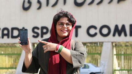 La journaliste sportive Raha Pourbakhsh montre du doigt les billets électroniques qu'elle vient d'acheter, mardi 8 octobre 2019, en vue de la rencontre entre l'Iran et le Cambodge à Téhéran. (ATTA KENARE / AFP)