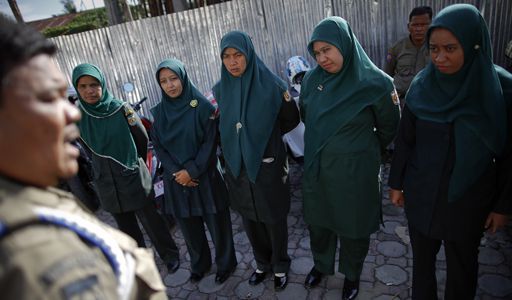 Des femmes membres de la Wilayatul Hisbah, la police de la charia, écoutent des instructions d'un supérieur à Banda Aceh (Sumatra) le 6 décembre 2012. Elles sont notamment chargées de pourchasser les couples non mariés dans les parcs et sur les plages.