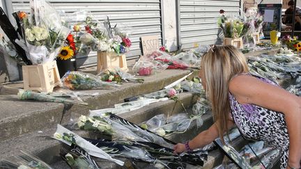  (Le 31 juillet, lors d'un rassemblement, les habitants de Dolomieu déposent des fleurs devant le tabac où Hugo Villerez a été assassiné  © MAXPPP / Le Dauphiné Libéré)