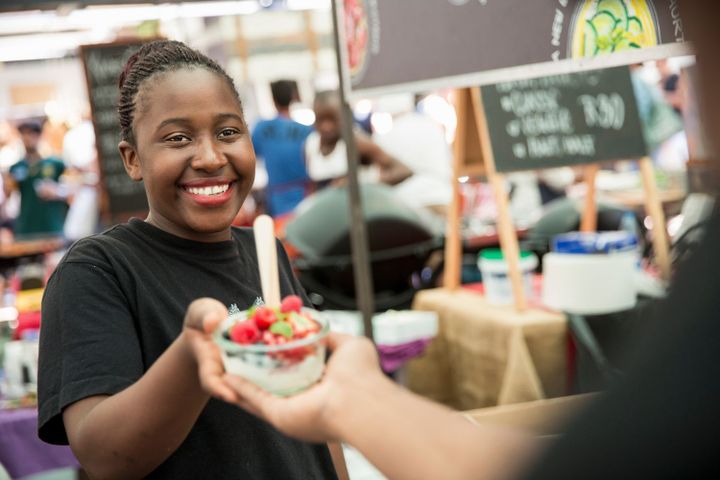 Une vendeuse sert une salade de fruits sur le marché d'une coopérative agricole (MATELLY / CULTURA CREATIVE)