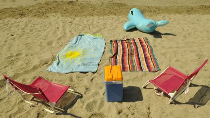 Fauteuils roses, serviettes de bain, glacière et bouée dauphin sur le sable... L'été enfin, la mer à 3h de chez soi en moyenne, la famille, le soleil et l'amour. C'est la grande transhumance estivale. (Illustration) (JP AMET / MAXPPP)