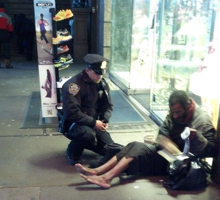 Une passante a photographi&eacute;, le 14 novembre 2012 &agrave; New York, un policier apportant des bottes &agrave; un SDF. Post&eacute; sur la page Facebook de la police new-yorkaise, le clich&eacute; a fait le tour des Etats-Unis. (JENNIFER FOSTER / SIPA / AP)