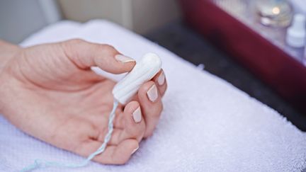 Une femme qui tient un tampon à Paris, en 2015. (ALICE S. / BSIP)