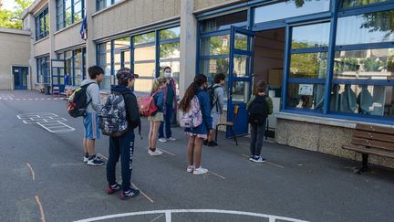 Des élèves attendent de rentrer en classe dans une école de Mantes-la-Jolie (Yvelines), le 19 mai 2020. (ISA HARSIN/SIPA)