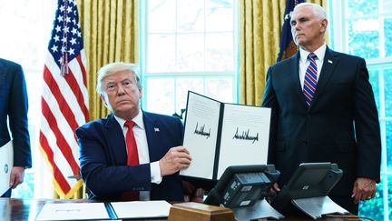 Donald Trump montre un document qui rétablit les sanctions contre l'Iran, le 24 juin 2019, à Washington. (MANDEL NGAN / AFP)