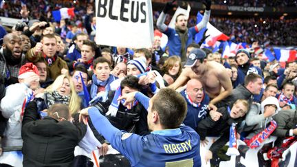 Franck Rib&eacute;ry salue les supporters de l'&eacute;quipe de France de foot, apr&egrave;s sa victoire en match de barrage contre l'Ukraine, au Stade de France, le 19 novembre 2013. (FRANCK FIFE / AFP)