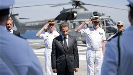 Le président Nicolas Sarkozy devant les troupes du porte-avions Charles-de-Gaulle le 12 août 2011 (AFP/BERTRAND LANGLOIS)