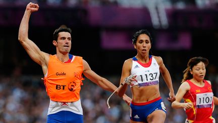  (L'athlète malvoyante française Assia El Hannouni a remporté au cours de sa carrière huit médailles d’or aux Jeux Paralympiques, dont deux sur 400 m et 200 m en 2012 à Londres (ci-contre avec son guide Gautier Simounet) © Maxppp)