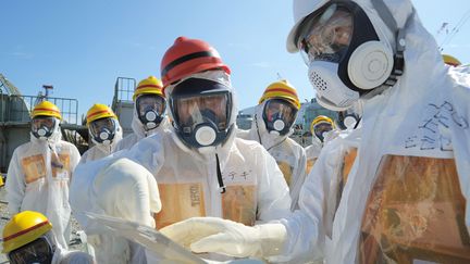 Le ministre japonais de l'Industrie (au centre), lors d'une visite du site de&nbsp;Fukushima (Japon), le 26 ao&ucirc;t 2013.&nbsp; (KYODO KYODO / REUTERS )