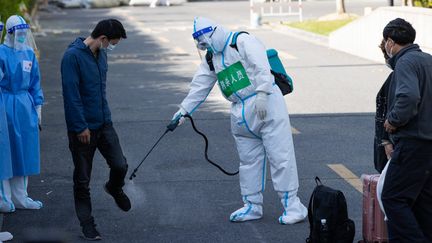 Un homme guéri du Covid-19 reçoit une dose de désinfection à Shanghai, le 9 avril 2022. (JIN LIWANG / XINHUA / AFP)